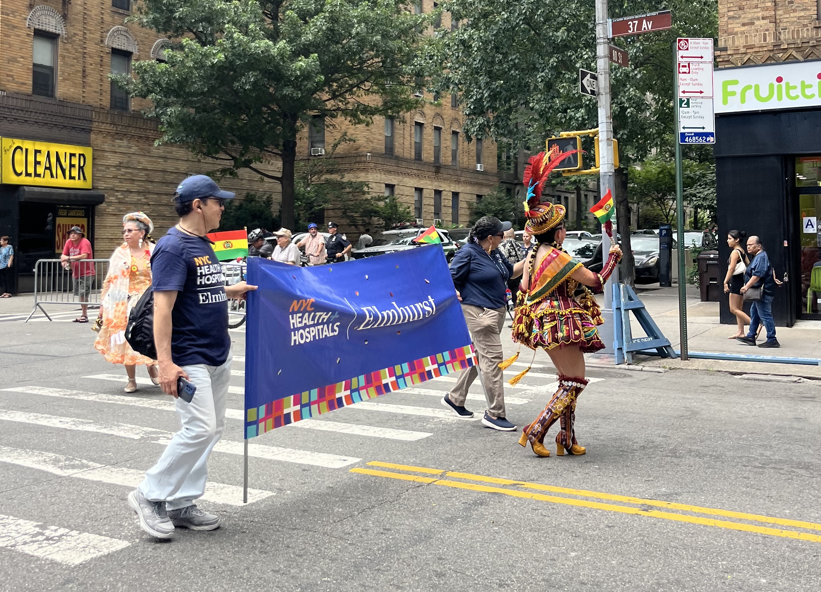 NYC Health + Hospitals/Elmhurst banner at Bolivian Day Parade in Jackson Heights. Taken by Thea Chung in July 2025.